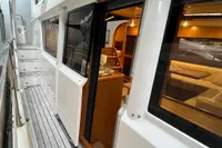 2007 Trader 42 HT yacht with open cabin door, showcasing luxurious interior and wooden deck.