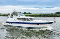 2007 Trader 42 HT yacht cruising on a river with scenic background.