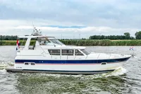 2007 Trader 42 HT yacht cruising on a river with scenic background.