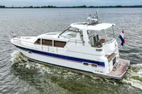 2007 Trader 42 HT yacht cruising on open water with Dutch flag.