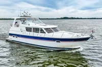 2007 Trader 42 HT yacht cruising on open water under a cloudy sky.
