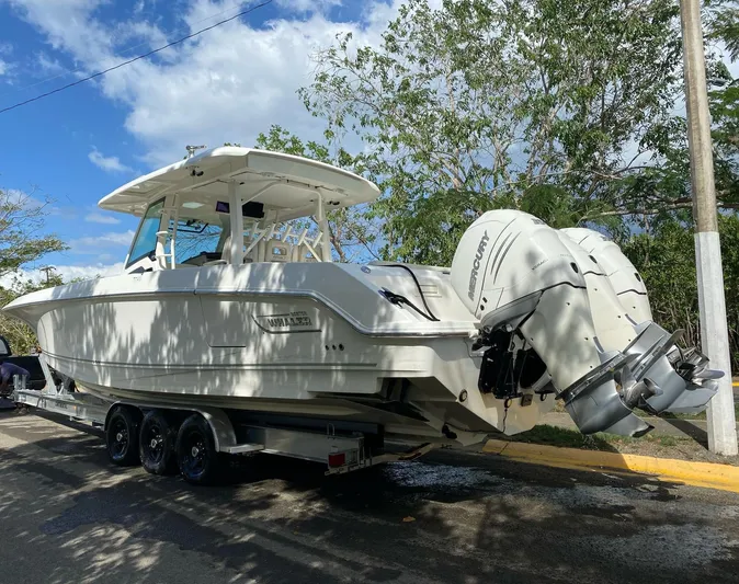  Yacht Photos Pics 2017 Boston Whaler 380 Outrage boat on trailer, parked under trees, with twin outboard engines.
