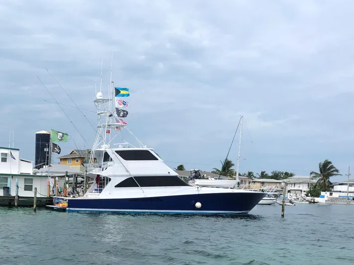 Killin Time Yacht Photos Pics 2003 Viking 65 Convertible Enclosed Bridge yacht docked near coastal buildings.