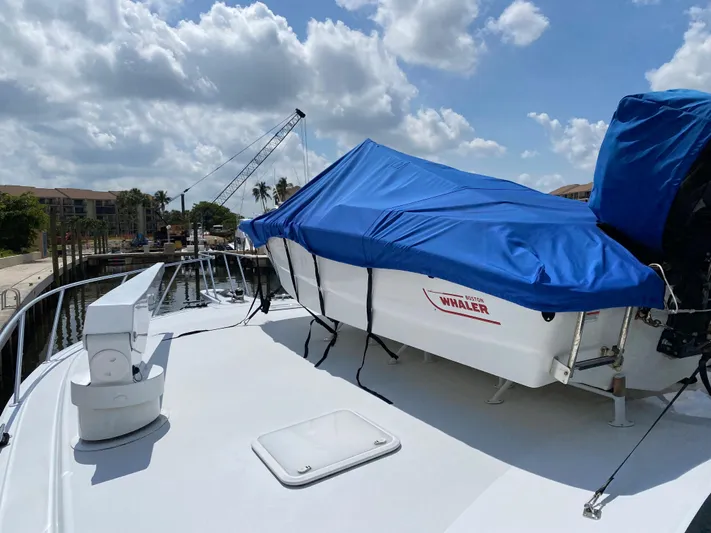 Killin Time Yacht Photos Pics 2003 Viking 65 Convertible Enclosed Bridge yacht with covered boat on deck, docked under cloudy sky.
