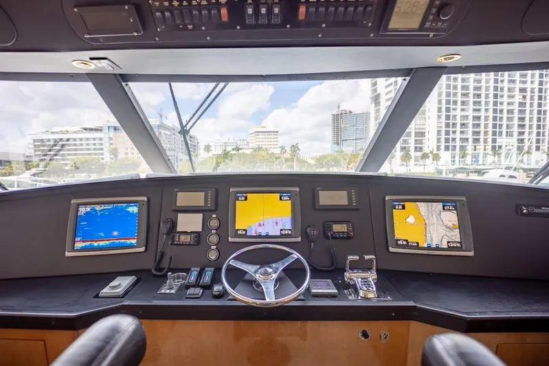 Killin Time Yacht Photos Pics 2003 Viking 65 Convertible Enclosed Bridge helm with navigation screens and cityscape view.