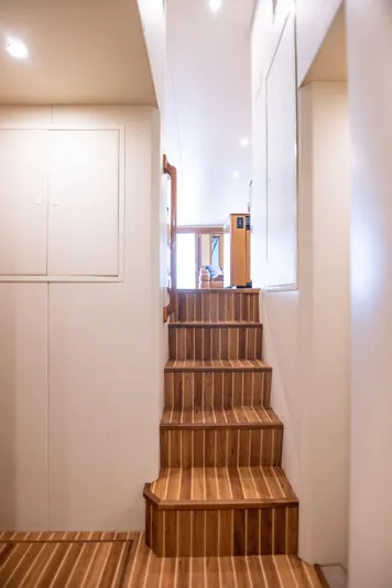 Killin Time Yacht Photos Pics Interior staircase of 2003 Viking 65 Convertible Enclosed Bridge yacht, featuring wooden steps.