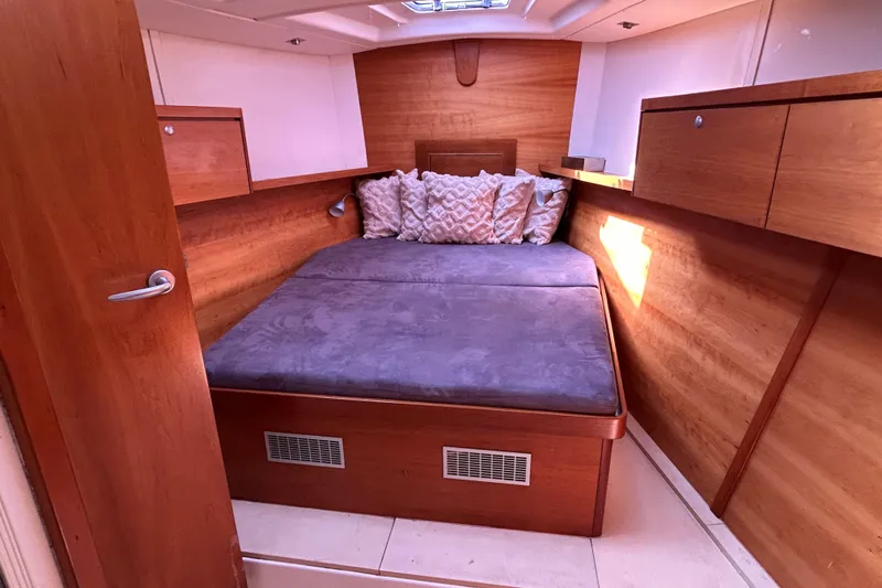 Scacciapensieri Yacht Photos Pics Cozy cabin interior of 2008 Hanse 470e yacht with wooden finish and plush bedding.