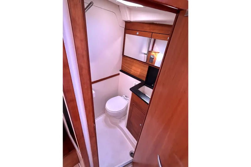 Scacciapensieri Yacht Photos Pics Bathroom interior of 2008 Hanse 470e yacht with wooden cabinetry and modern fixtures.