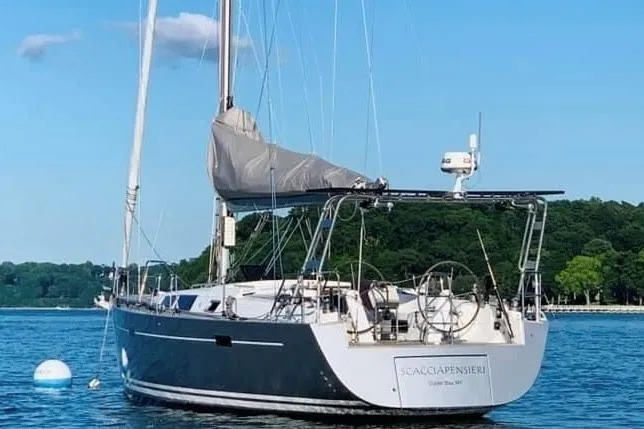 Scacciapensieri Yacht Photos Pics 2008 Hanse 470e sailboat anchored on calm water with lush green shoreline.
