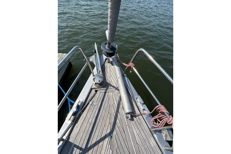 Scacciapensieri Yacht Photos Pics Bow of 2008 Hanse 470e sailboat with deck fittings and railing, docked by water.