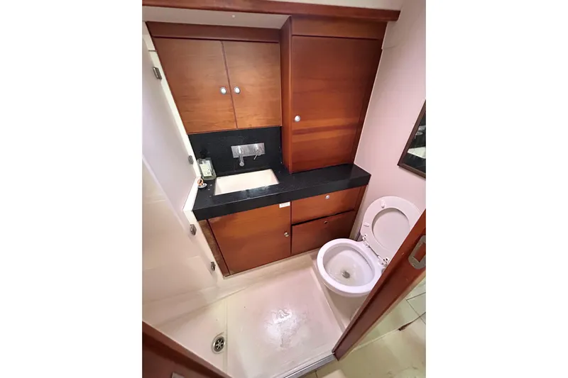 Scacciapensieri Yacht Photos Pics Bathroom interior of 2008 Hanse 470e yacht with wooden cabinetry and modern fixtures.