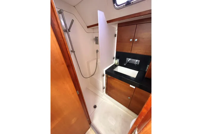 Scacciapensieri Yacht Photos Pics Bathroom interior of 2008 Hanse 470e yacht with shower and wooden cabinetry.