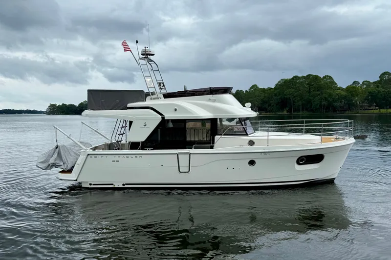  Yacht Photos Pics 2025 Beneteau Swift Trawler 35 on calm water under cloudy sky.