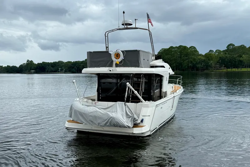  Yacht Photos Pics 2025 Beneteau Swift Trawler 35 on a serene lake under cloudy skies.