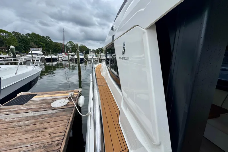  Yacht Photos Pics 2025 Beneteau Swift Trawler 35 docked, showcasing sleek design and wooden deck.
