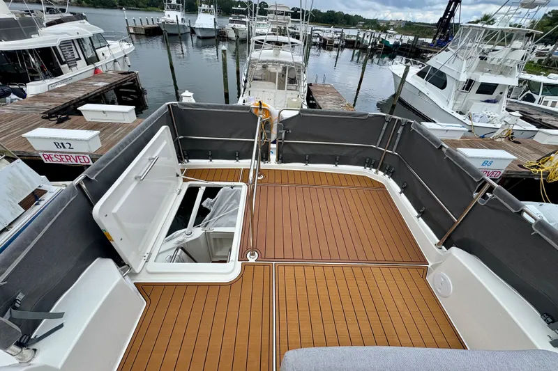  Yacht Photos Pics 2025 Beneteau Swift Trawler 35 deck at marina, featuring teak flooring and open hatch.