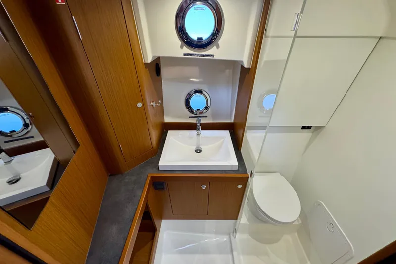  Yacht Photos Pics Luxurious bathroom in 2025 Beneteau Swift Trawler 35 with modern fixtures and porthole windows.