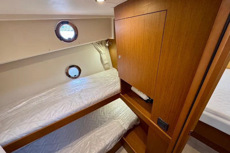 Yacht Photos Pics 2025 Beneteau Swift Trawler 35 cabin with wooden interior and bunk beds.