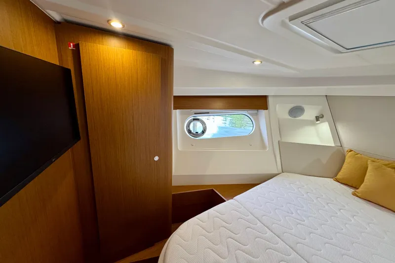  Yacht Photos Pics Luxurious cabin interior of 2025 Beneteau Swift Trawler 35 with cozy bed and porthole view.