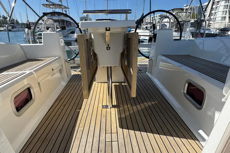 Moonraker Yacht Photos Pics 2014 Beneteau Oceanis 38 yacht cockpit with wooden flooring and dual steering wheels.