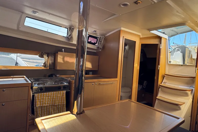 Moonraker Yacht Photos Pics Interior of 2014 Beneteau Oceanis 38 sailboat with kitchen and wooden cabinetry.