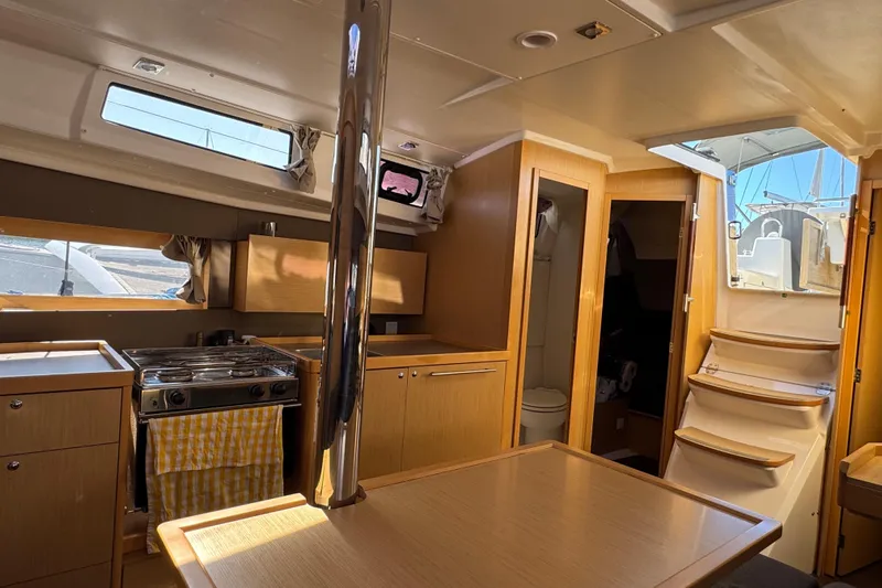 Moonraker Yacht Photos Pics Interior of 2014 Beneteau Oceanis 38 sailboat with kitchen and wooden cabinetry.