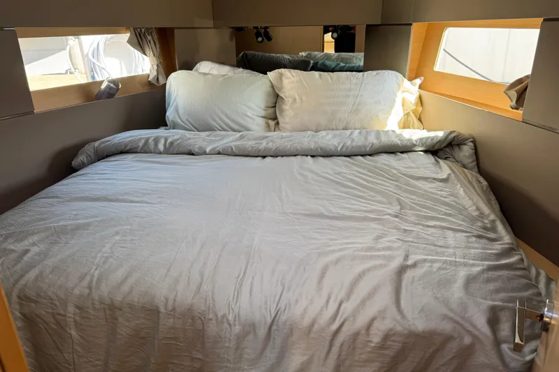Moonraker Yacht Photos Pics Cozy cabin bed in 2014 Beneteau Oceanis 38 sailboat, featuring soft bedding and natural light.