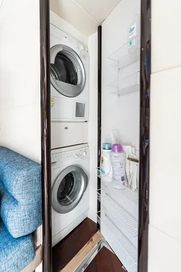Liquid Asset Yacht Photos Pics Laundry area with stacked washer and dryer on 2010 Lazzara 78 Fly yacht.
