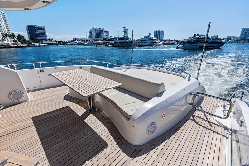 Liquid Asset Yacht Photos Pics 2010 Lazzara 78 Fly yacht deck with seating and table, cruising in a marina.