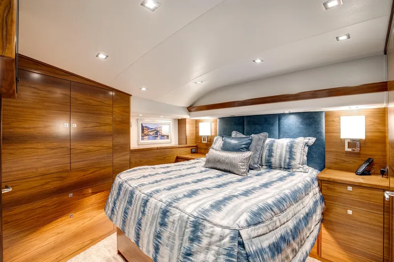 La Barca Yacht Photos Pics Luxurious 2024 Viking 68 Convertible yacht bedroom with elegant wood paneling and plush bedding.