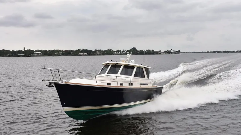 Moondance Yacht Photos Pics 2006 Sabre 42 Express yacht cruising on a calm, overcast waterway.