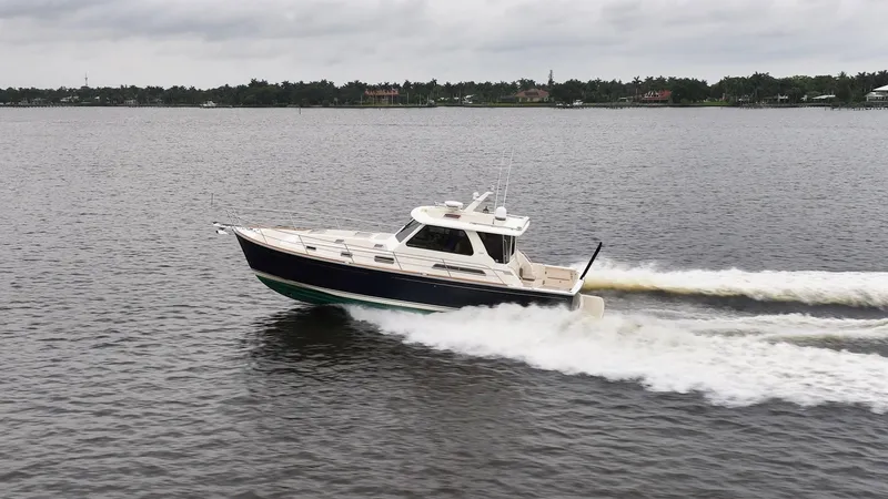 Moondance Yacht Photos Pics 2006 Sabre 42 Express cruising on a calm lake under cloudy skies.