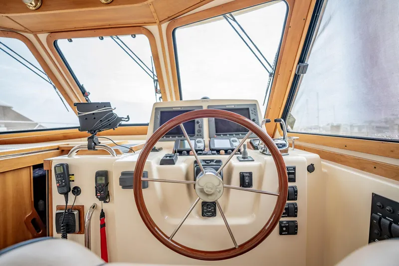 Moondance Yacht Photos Pics Helm of 2006 Sabre 42 Express yacht with wooden steering wheel and navigation equipment.