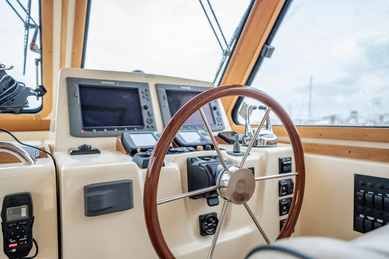 Moondance Yacht Photos Pics Helm of 2006 Sabre 42 Express yacht with wooden steering wheel and navigation equipment.