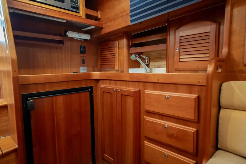 Moondance Yacht Photos Pics Interior of 2006 Sabre 42 Express yacht with wooden cabinetry and compact kitchen area.