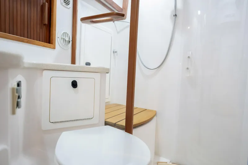 Moondance Yacht Photos Pics 2006 Sabre 42 Express yacht bathroom with shower, wooden accents, and storage cabinet.