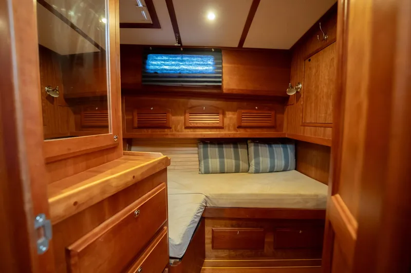 Moondance Yacht Photos Pics Cozy cabin interior of 2006 Sabre 42 Express yacht with wooden finish and striped cushions.