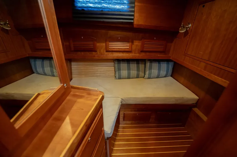 Moondance Yacht Photos Pics Cozy cabin interior of 2006 Sabre 42 Express yacht with wooden finish and striped cushions.