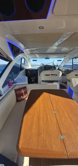 Mambo Italiano Yacht Photos Pics Interior of 2015 Beneteau 38 Gran Tourismo yacht with wooden table and modern seating.
