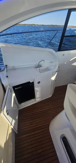 Mambo Italiano Yacht Photos Pics 2015 Beneteau 38 Gran Tourismo yacht interior with open cabinet, wooden flooring, and ocean view.