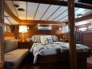  Yacht Photos Pics Luxurious cabin interior of 1984 Tayana 55 yacht with cozy bed and ambient lighting.