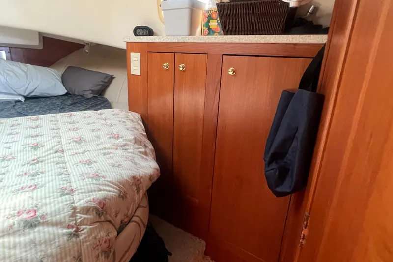 Beryl W Yacht Photos Pics Cozy cabin interior of 2001 Mainship 390 Trawler with floral bedding and wooden cabinetry.
