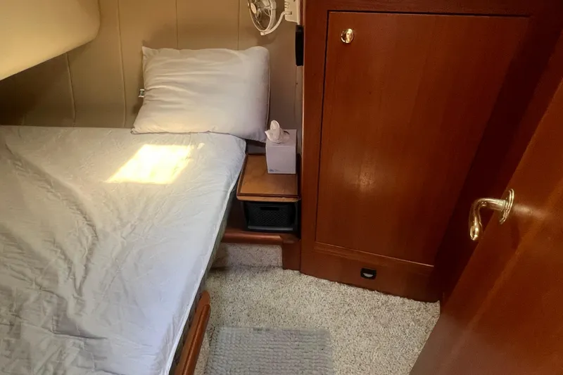 Beryl W Yacht Photos Pics Cozy cabin interior of 2001 Mainship 390 Trawler with bed and wooden cabinetry.