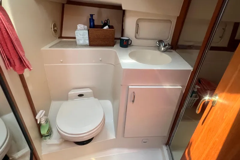 Beryl W Yacht Photos Pics Bathroom interior of 2001 Mainship 390 Trawler with sink, toilet, and storage.
