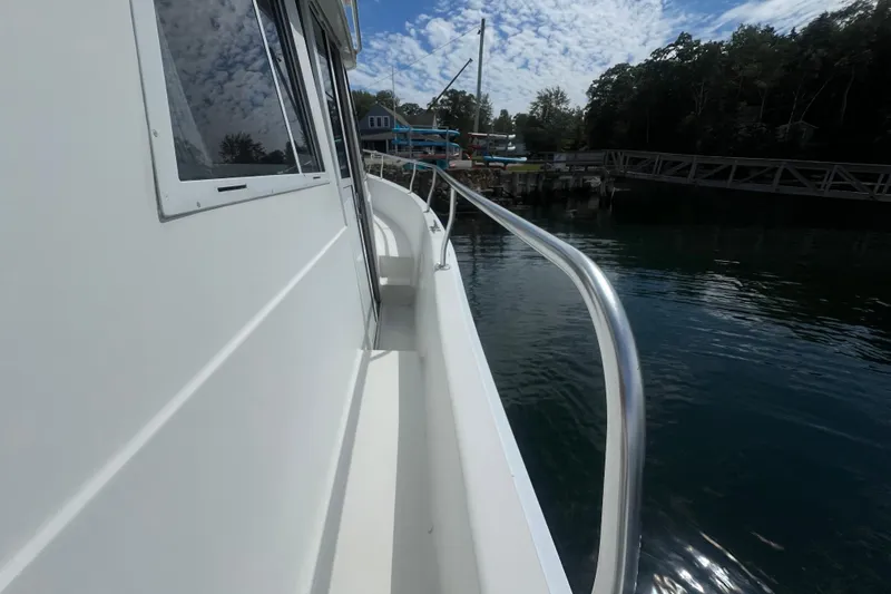 Beryl W Yacht Photos Pics 2001 Mainship 390 Trawler docked, side view with railing and water reflection.