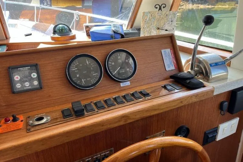 Beryl W Yacht Photos Pics 2001 Mainship 390 Trawler helm with gauges, controls, and wooden steering wheel.