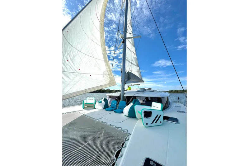 Sweet And Salty Yacht Photos Pics 2018 Fountaine Pajot Helia 44 Evolution sailing catamaran with open sails under a clear blue sky.