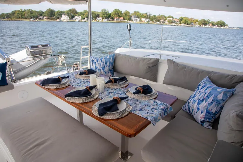 Sweet And Salty Yacht Photos Pics Luxurious dining setup on 2018 Fountaine Pajot Helia 44 Evolution catamaran, overlooking serene waters.