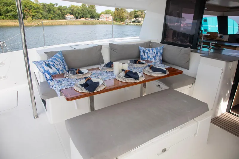 Sweet And Salty Yacht Photos Pics Outdoor dining area on 2018 Fountaine Pajot Helia 44 Evolution catamaran, set for a meal.