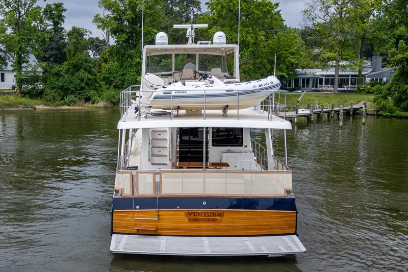 Venture Yacht Photos Pics Grand Banks 54 Europa 2014 yacht docked on a serene river with lush greenery.